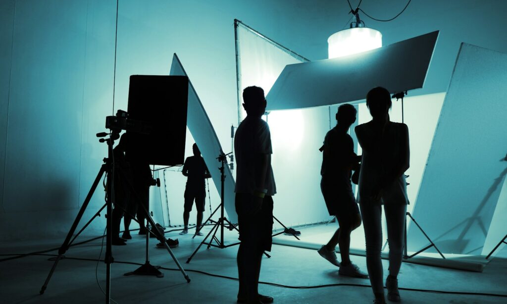 High Contrast silhouette images of production crew team working in photo shooting studio and LED hea